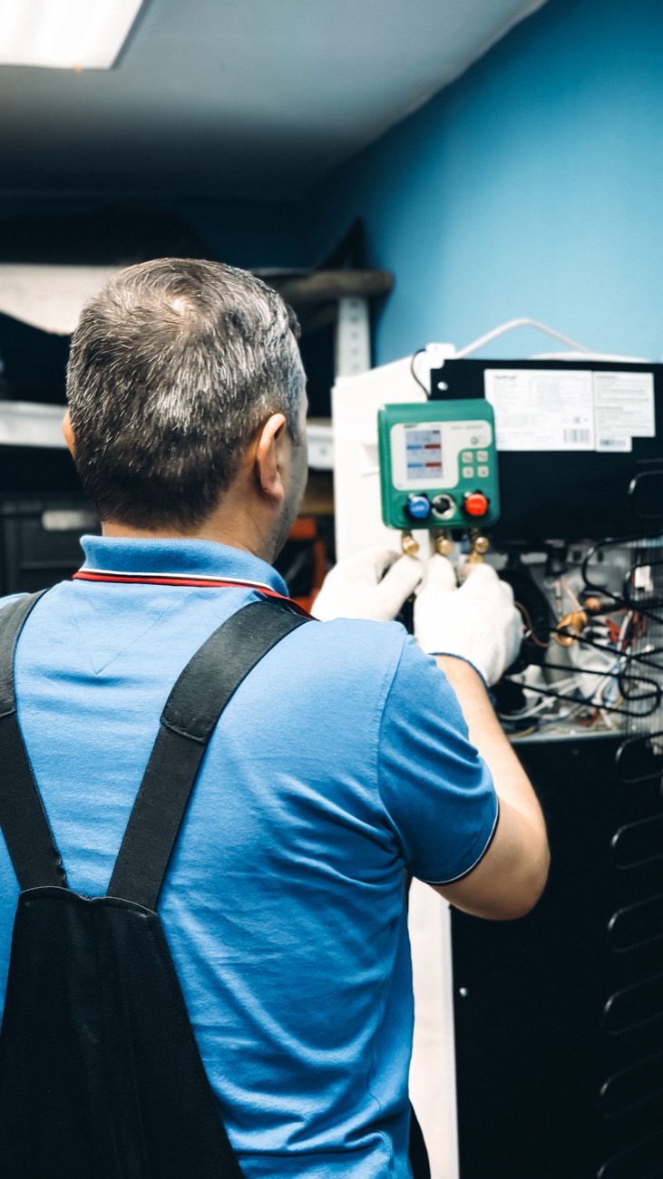 Technicien contrôlant une installation de chauffage aux manomètres